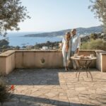 Elegant couple on luxury villa terrace with coastal view