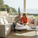 Couple reviewing luxury home plans in bright living room