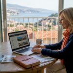 Woman researching property on laptop near Riviera view