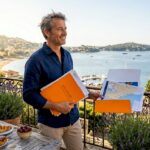 Investor reviewing paperwork on Riviera villa balcony