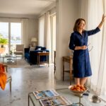 Woman opens curtains in luxury Riviera villa