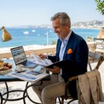 Investor reviewing property portfolio in sunlit Riviera office