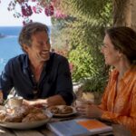 Couple enjoying breakfast on terrace by the beach