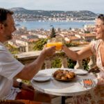 Couple enjoying drinks on sunny Paris terrace