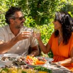 Couple enjoying drinks on sunny beach terrace