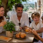 Happy family enjoying drinks on sunny beach terrace