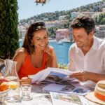 Happy couple reviewing property papers on terrace
