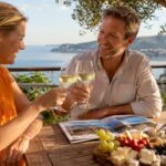 Happy couple on sunny terrace discussing property