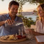 Couple pouring drinks on terrace buying house
