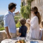 Family discussing Riviera villa on sunny terrace