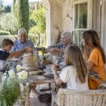 Three generations dining on a Riviera villa loggia